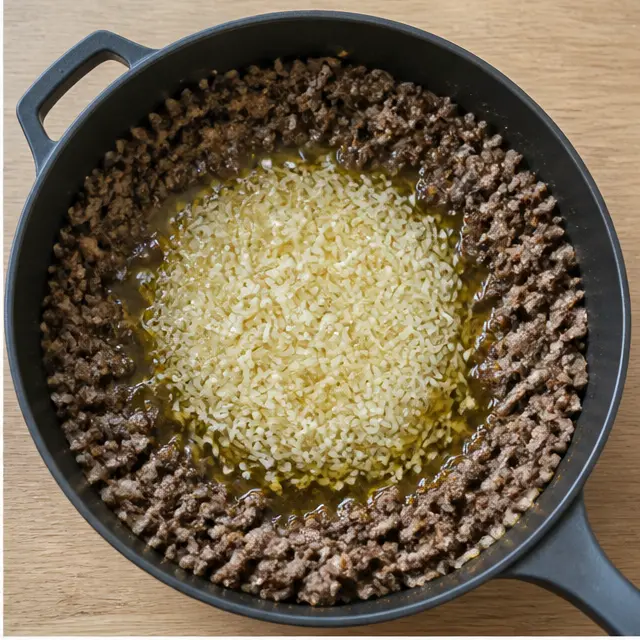 Toasting rinsed jasmine rice in olive oil with beef pushed to the edges