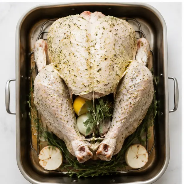 Roasting the trussed bird with lemon, onion, and herb bunches