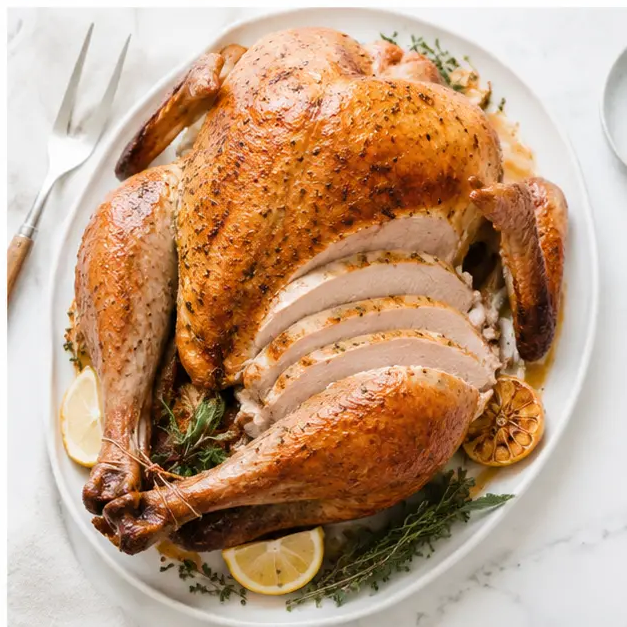 Carving the rested golden turkey with pan juices
