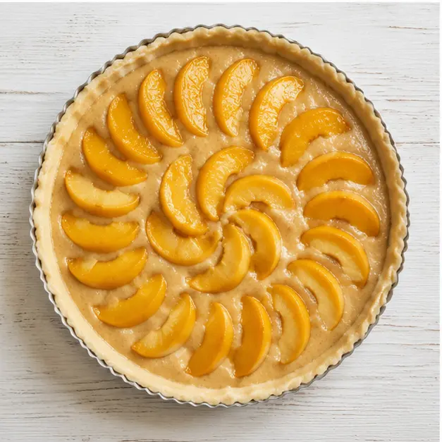 Spread the almond cream filling in the chilled shell and arrange sliced peaches in circles.