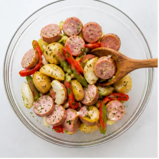 Step 1: Tossing the raw ingredients with olive oil and Italian seasoning to coat everything evenly.
