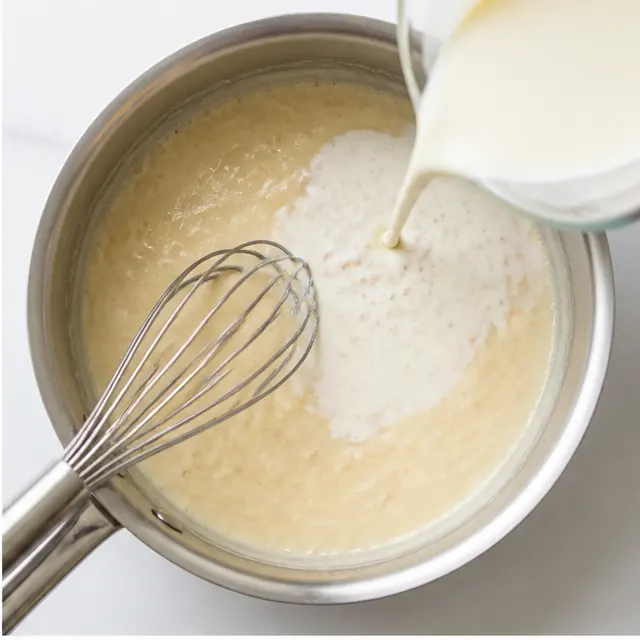 Whisking flour and liquids into a creamy sauce