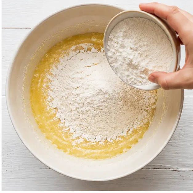 Sprinkle dry ingredients over the wet mixture and mix to a cohesive dough