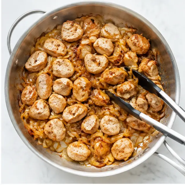 Bite-size chicken fillets browning with caramelized onions and garlic