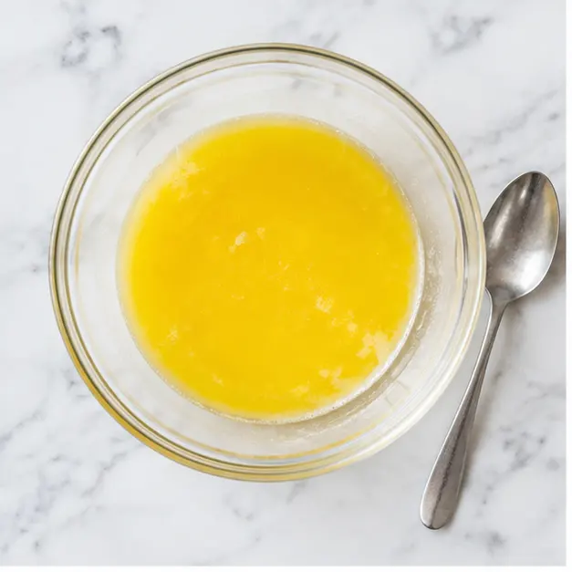 Melting unsalted butter until glossy and liquid