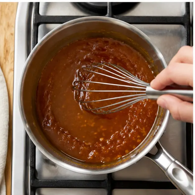 Step 3: Simmering and whisking the sauce until it turns thick and glossy