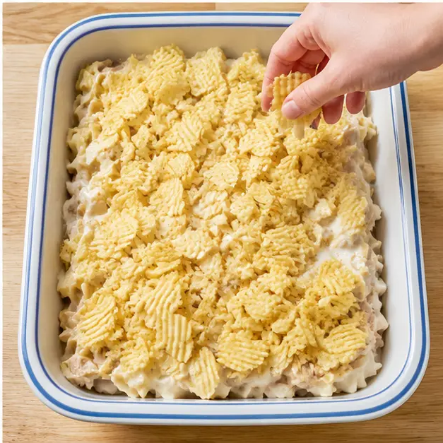 Scattering crushed ridged potato chips over the assembled casserole